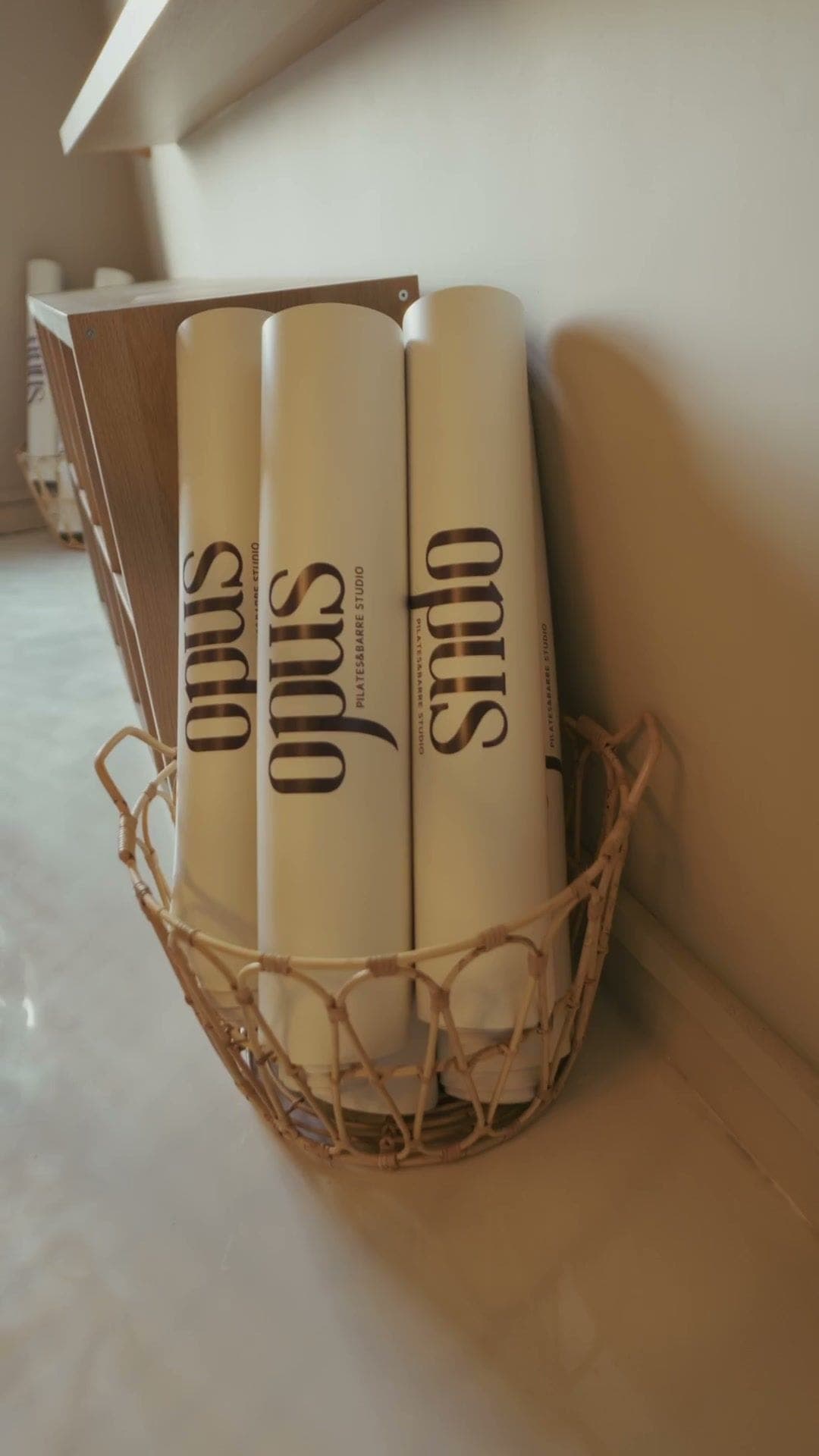Rolled mats printed with the opus wordmark in a woven basket